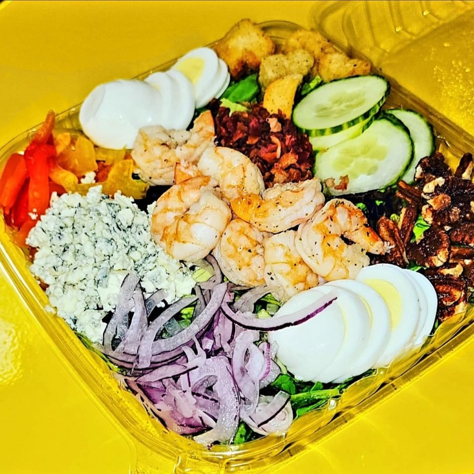 A vibrant TATERSALADZ salad with shrimp, blue cheese, red onions, and hard-boiled eggs.